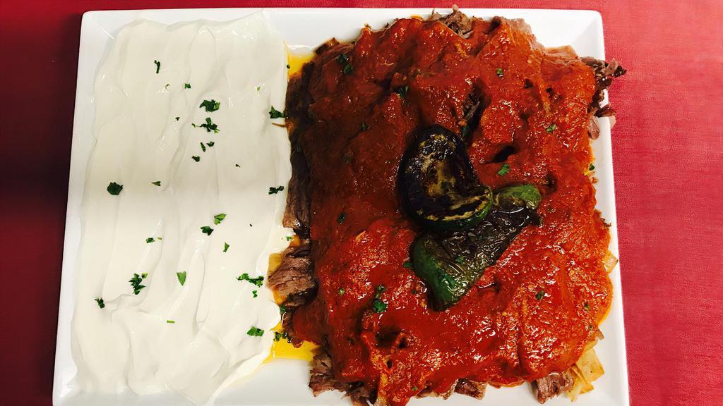 Iskender Kebab · Thinly-sliced, roasted lamb served over sliced pita covered in a tomato and butter sauce. Served with a generous portion of yogurt.