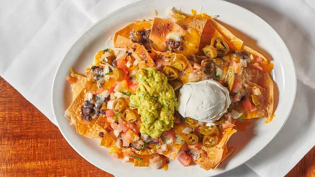 Nachos · Tortilla chips individually layered with black beans, jack and cheddar cheeses, topped with salsa cruda, sour cream, guacamole and jalapenos.
