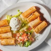 Taquitos · Crisp bite-sized corn tortillas stuffed with shredded chicken served with sour cream and sal...