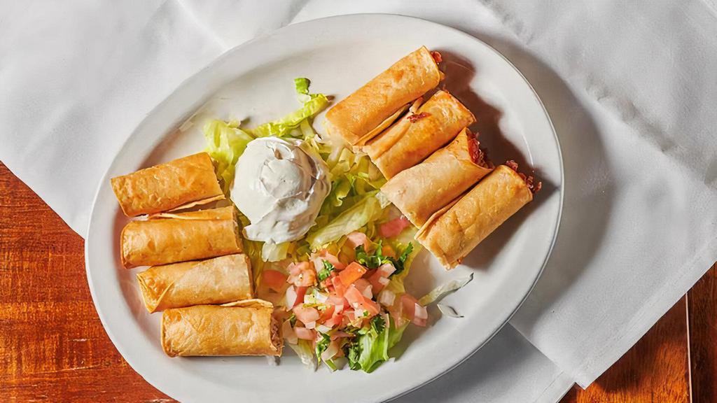 Taquitos · Crisp bite-sized corn tortillas stuffed with shredded chicken served with sour cream and salsa cruda.