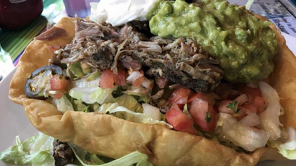 Carnitas Salad · Tender cooked carnitas sliced and served with beans, sour cream, guacamole, salsa cruda, jalapenos and olives, layered over fresh greens.