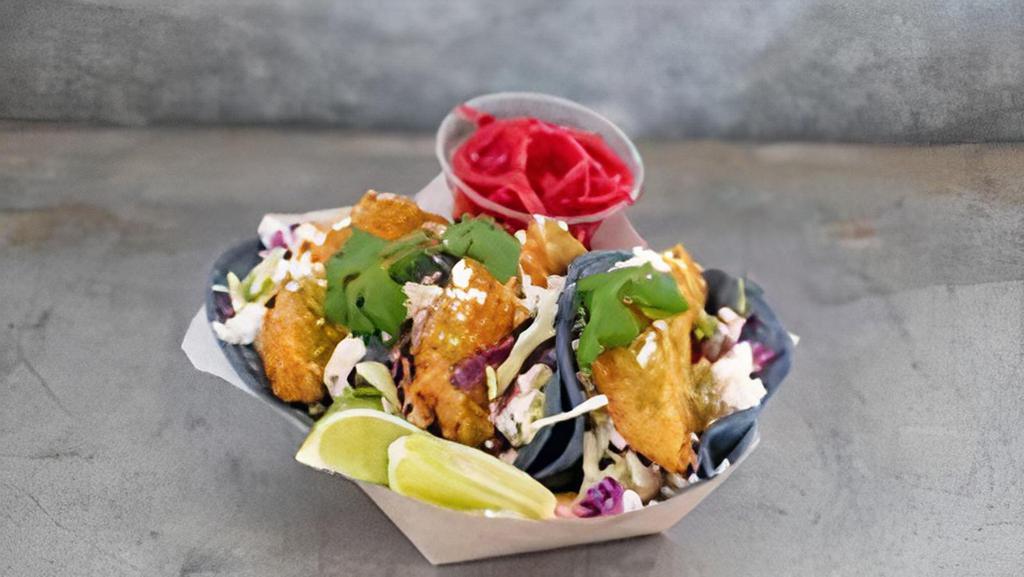 Avocado Tacos · Crispy fried avocados served in soft, blue corn tortillas with cabbage & cilantro slaw, queso fresco, salsa verde, red onions, lime & chipotle mayo. 3 tacos per order
