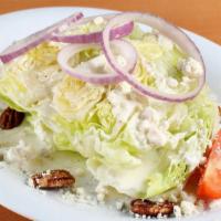 The “Iceberg Wedge” · W/ tomato, red onion, spiced pecans, & our blue cheese dressing.