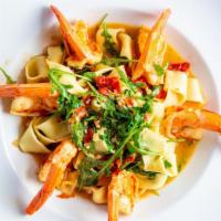 Homemade Saffron Pappardelle · Wide saffron pasta sauce with tiger prawns, baby arugula, sun-dried tomatoes with a light lo...