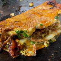 Quesabirria · The quesabirria a delicious semi crisp tortilla is dipped in braising liquid and seared on a...