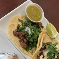 1. Steak Taco · Steak taco topped with onions and cilantro and green sauce