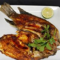 Tilapia al Fogón · Tilapia fried in a very spice oil sauce. Comes with a side of rice, beans and salad