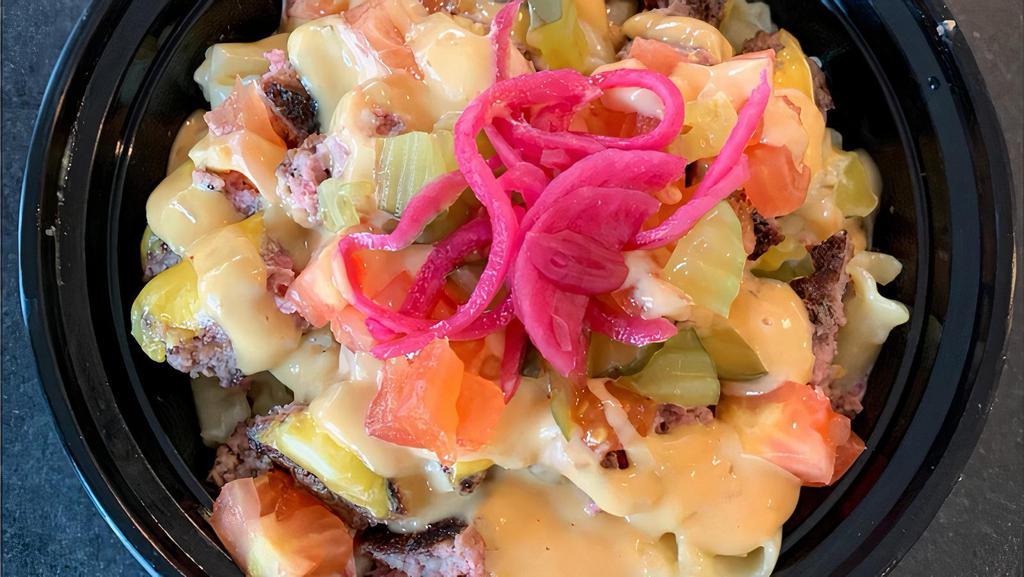 Loaded Cheeseburger Mac · grilled angus beef patty, american cheese, pickled red onion, tomatoes, pickles, and signature sauce drizzle.