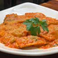 Ravioli Emiliana · meat and spinach ravioli, in a delicate tomato and cream sauce with imported grana padano ch...