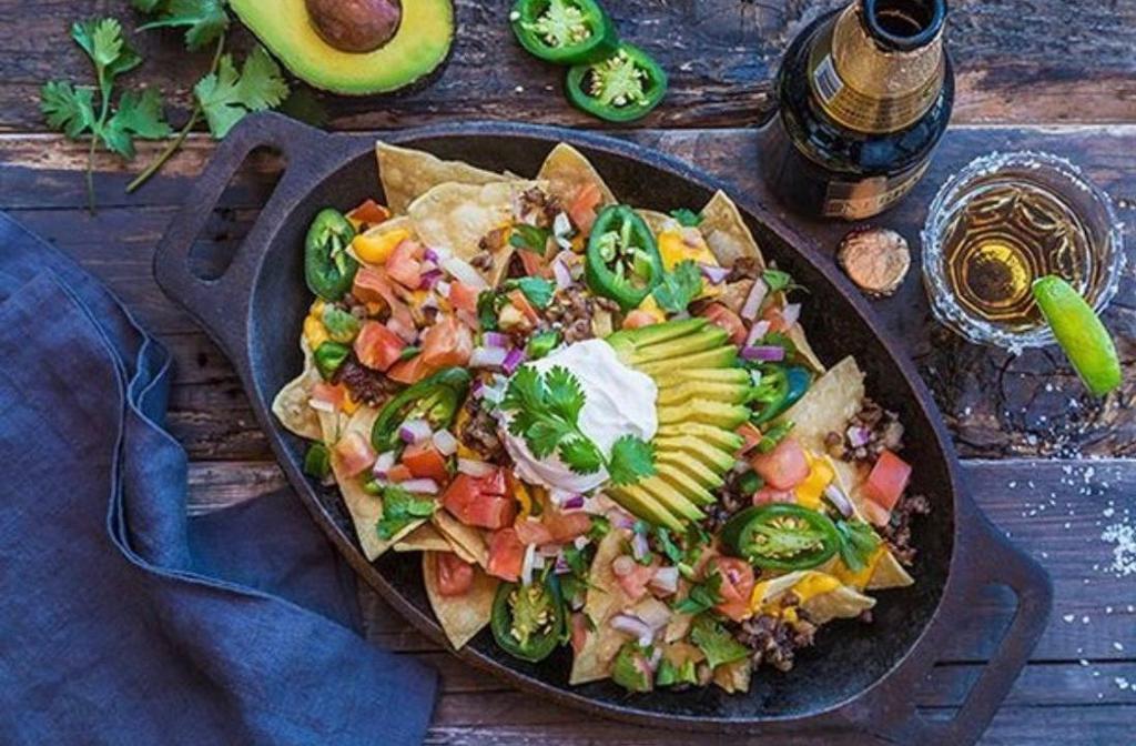 Loaded Nachos · Crispy home made chips w/ EVERYTHING:  avocado, sour cream, salsa, nacho cheese, jalapeños and your choice of Angus ground beef chuck, grilled chicken breast or our special pork sisig.