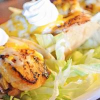 Fish Tacos · Three tacos in soft corn tortillas topped with grilled fish, lettuce, salsa, sour cream and ...