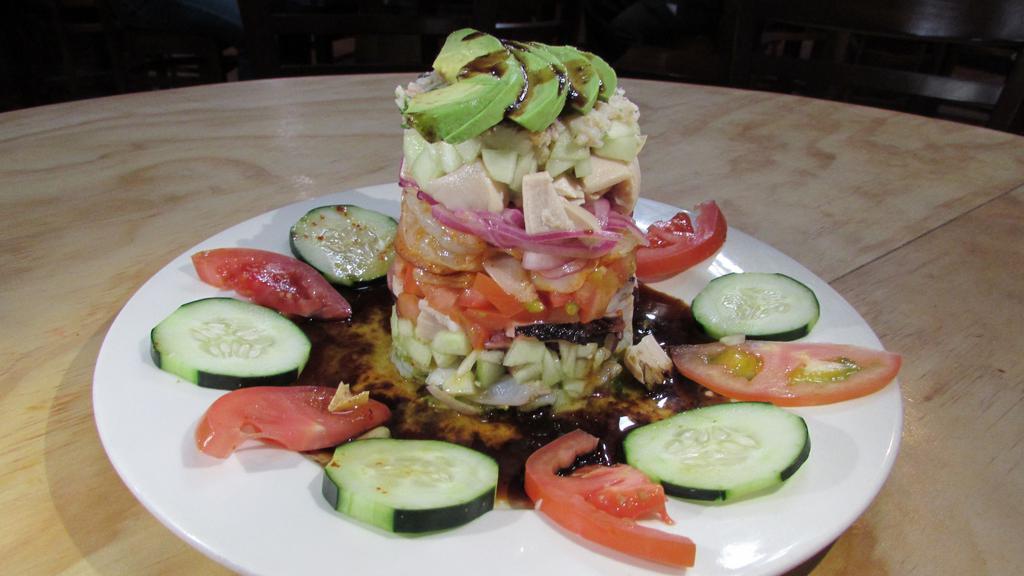 Tostada Torre · Octopus, crab, raw & cooked shrimp,
 fish ceviche, mango, avocado, cucumber, red onion.