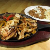 Fajitas Trio · Delicious slightly spiced strips of meat, chicken & shrimp, sauteed with red and green bell ...