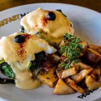 Eggs Benedict Florentine · Spinach and fresh tomato. English muffin topped with poached eggs, smothered with hollandais...