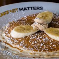 Banana Pancakes · Our buttermilk premium pancakes filled with diced fresh bananas, served with whipped butter ...