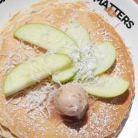 Apple Coconut Pancakes · Filled and topped with hot toasted coconut. Lightly dusted with powdered sugar, served with ...