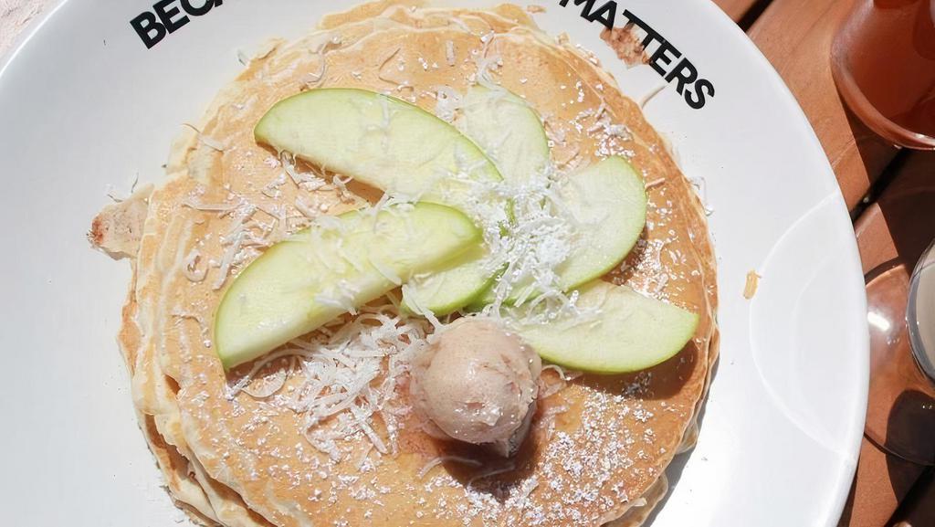 Apple Coconut Pancakes · Filled and topped with hot toasted coconut. Lightly dusted with powdered sugar, served with whipped butter and hot tropical syrup.