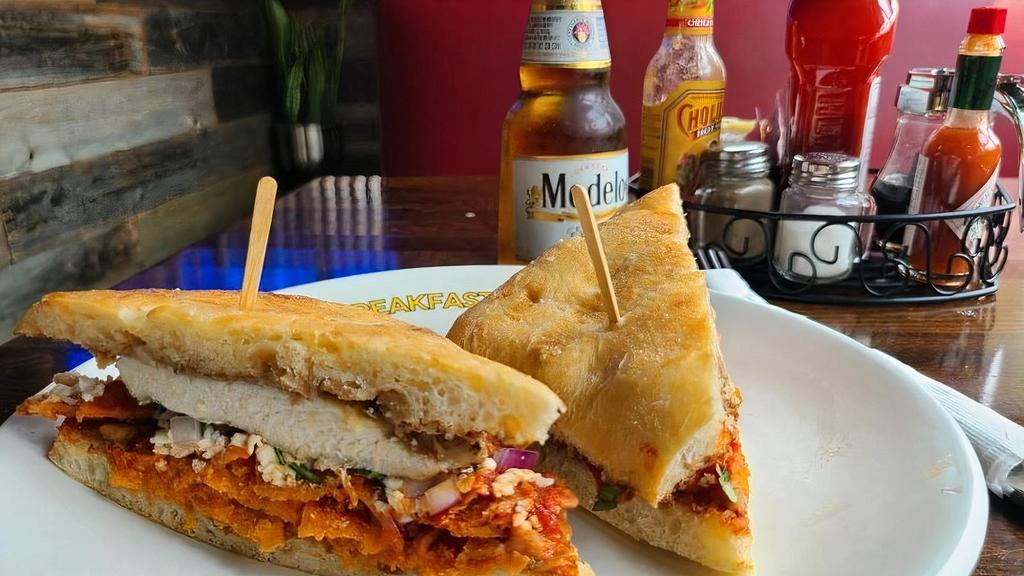 Torta de Chilaquiles · With bread chicken, black refried beans, Mexican cheese, and sour cream.