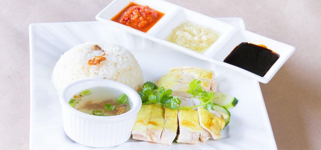 Singapore Chicken Rice · A famous Singaporean staple of freshly poached chicken, served with aromatic chicken flavored rice and chili-ginger sauce.