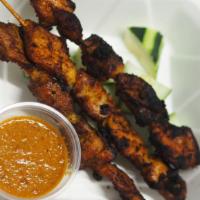 Chicken Satay · Spiced marinated chicken skewers with cucumber and peanut sauce.