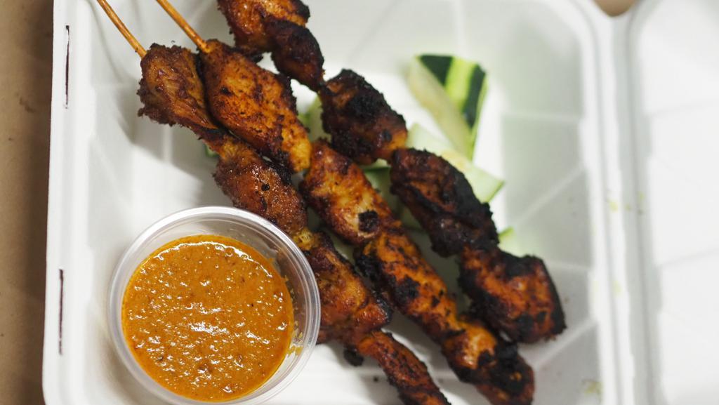 Chicken Satay · Spiced marinated chicken skewers with cucumber and peanut sauce.
