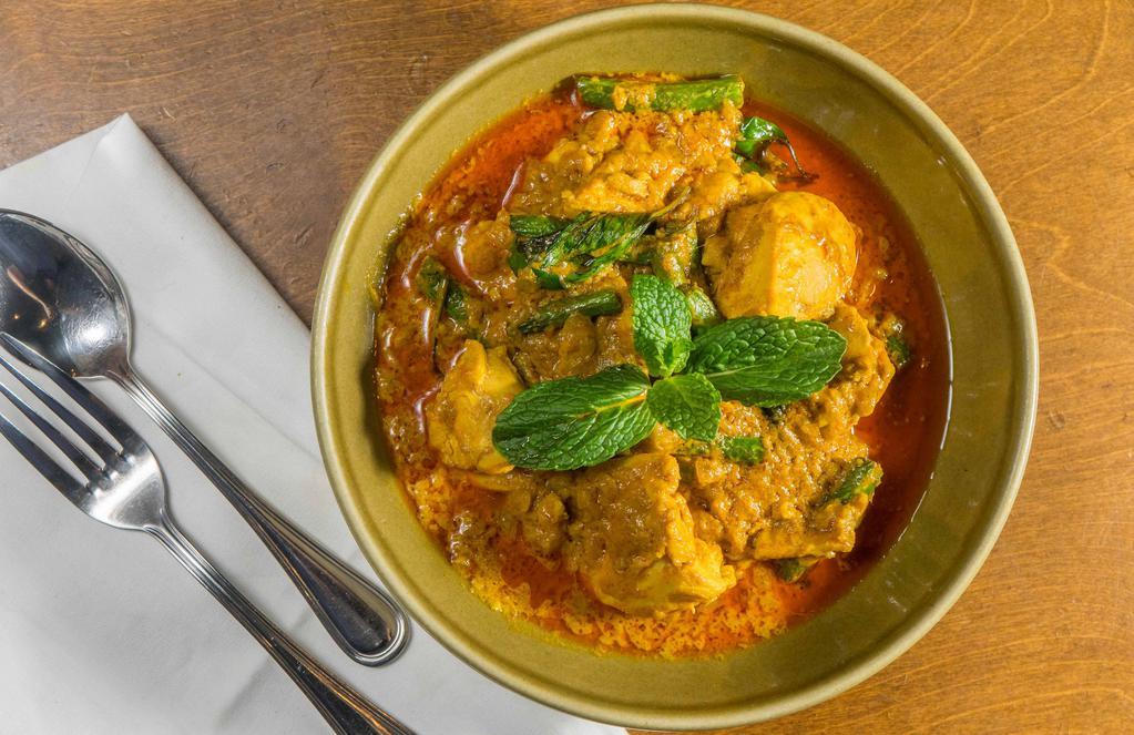 Coconut Chicken Curry · Chicken thighs simmered in an aromatic stew of coconut milk, turmeric, Thai basil, string beans and chili. Mild or extra spicy upon request.