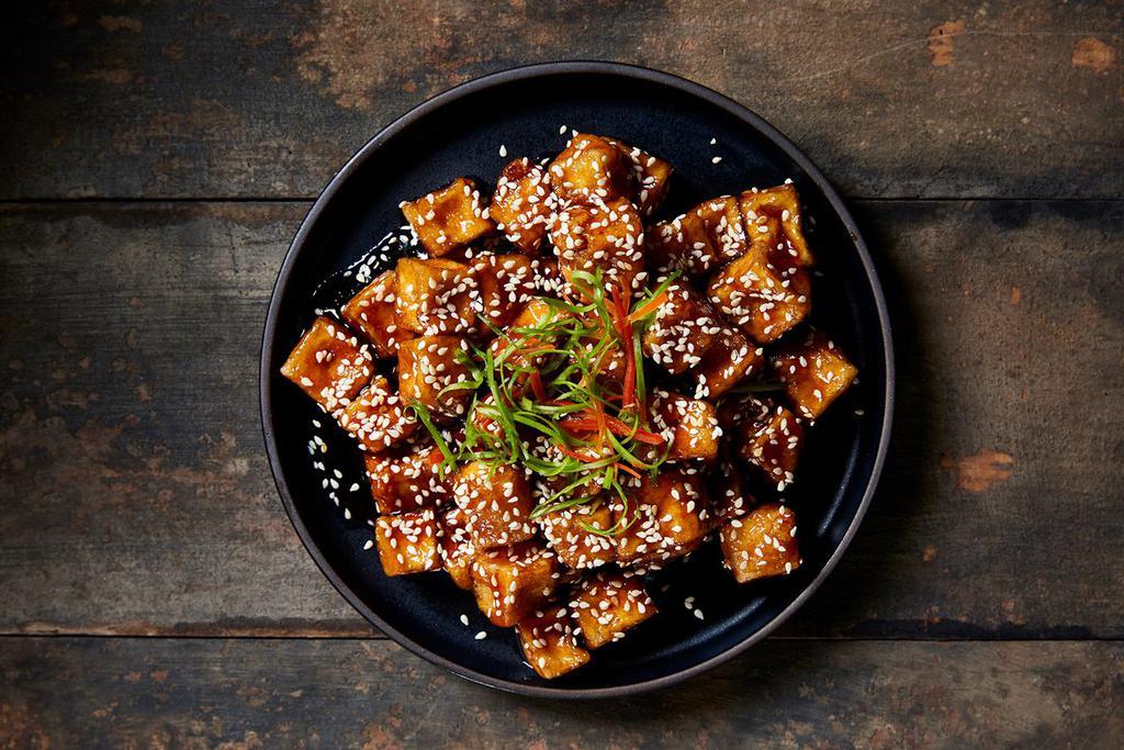 Sesame Tofu · Lightly fried tofu cooked with a sweet and tangy sauce topped with sesame seeds.
