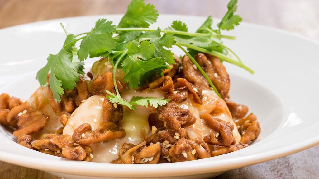 Walnut Shrimp · Shrimp lightly fried and tossed in our wok with a sweet cream sauce. Topped with roasted walnuts and sesame seeds.
