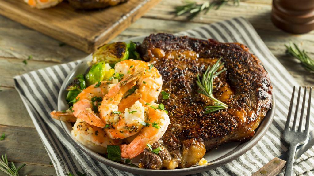 Ribeye Steak with Prawns · A mouthwatering 10 oz Grilled Ribeye Steak seasoned to perfection with 4 prawns. Served with a side of Rice, beans, side salad, and homemade tortillas.