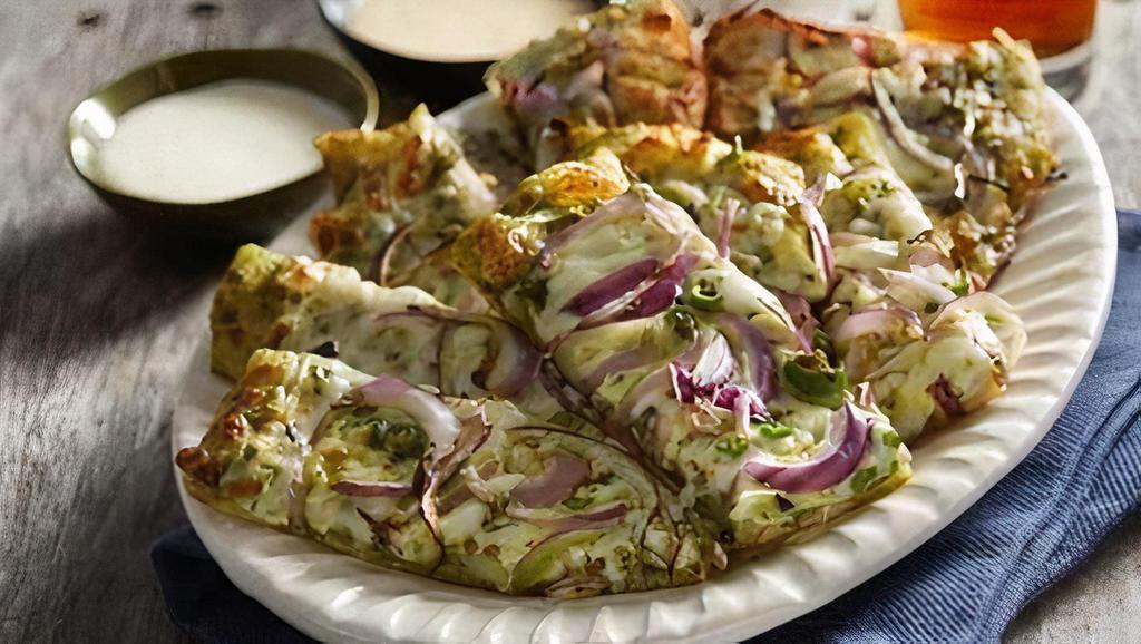 Desi Garlic Sticks · Cheesy pesto bread-sticks topped with red onions and green chilies