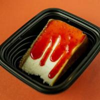 New York Style Cheesecake · Traditional graham cracker crust cheesecake with strawberry sauce.