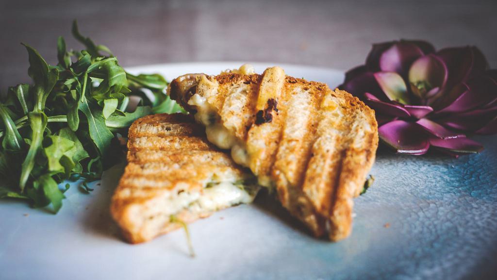 Black Truffle Grilled Cheese · Gluten-free bread, black truffle ghee, arugula, organic cheddar cheese, and organic pepper jack cheese. Served with green sauce on the side.