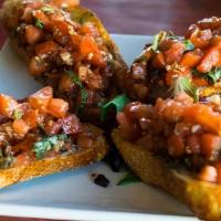 Bruschetta · Toasted sourdough topped with diced roma tomatoes, garlic and basil marinated in extra virgi...