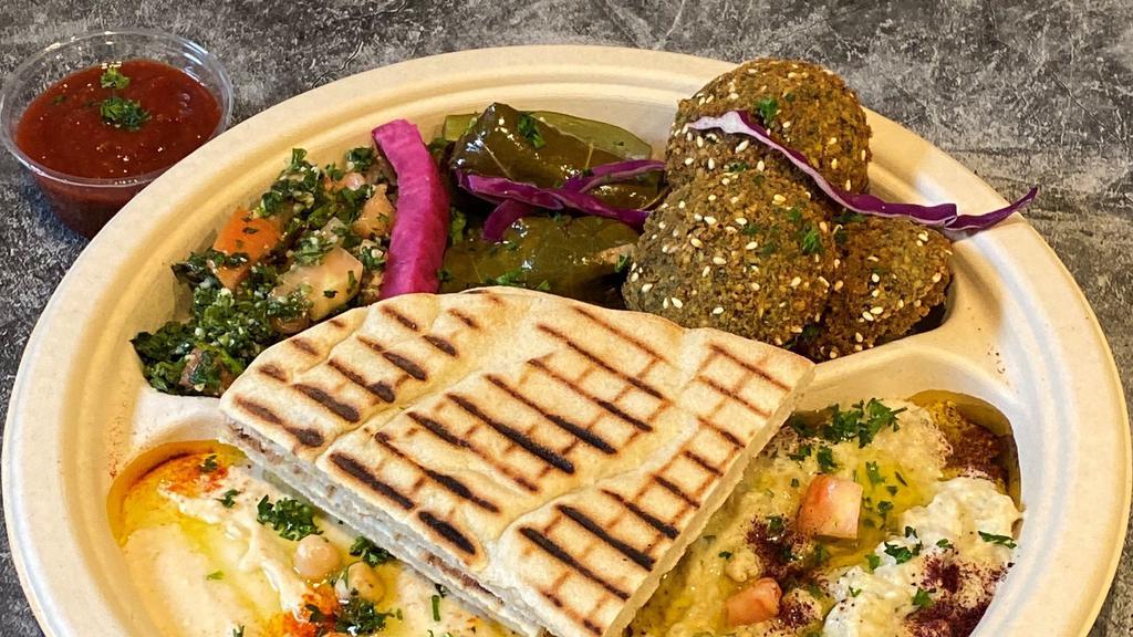 Falafel Plate · Turmeric Rice Topped With Fresh Falafels, Tomatoes, Onions and Tahini Sauce Served With a Side of Hummus, Cabbage Slaw and Pita Bread.