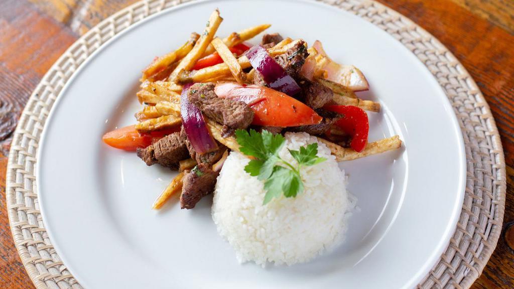 Lomo Saltado (Catering) · Steak strip stir fry with red onion, tomatoes, red bell pepper, cilantro, soy sauce, and papas fritas, served with a side of Brazilian rice.