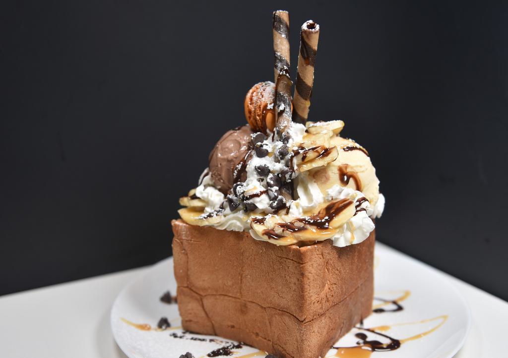 Banana Loco Bread House · Our Banana Loco Bread House comes with one scoop chocolate ice cream, one scoop vanilla ice cream. Fresh cut banana, chocolate chip topping. Chocolate and caramel syrup.