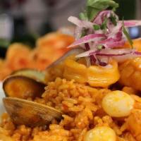 Arroz Con Mariscos · Fried rice with ají panca, wine, sautéed mussels, calamari, red onions, tomatoes & corn, top...
