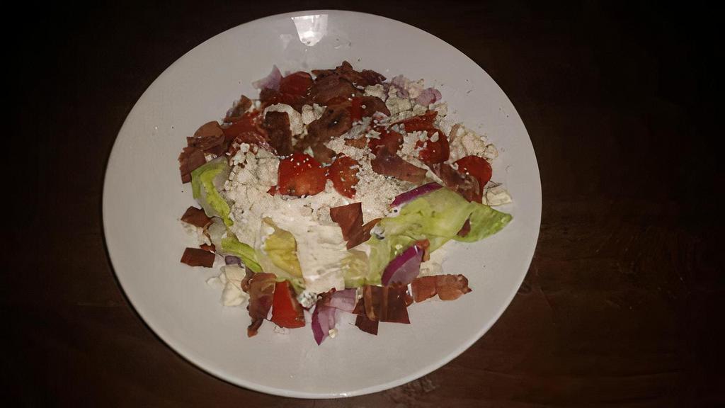 Wedge Salad · Iceberg Wedge, Bacon, Red Onion, Blue Cheese Crumbles and Grape Tomato served with Bleu Cheese Dressing.