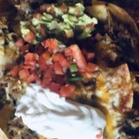 Nachos · Tortilla chips topped with refried beans, cheese, crema, pico de gallo, guacamole, and jalap...