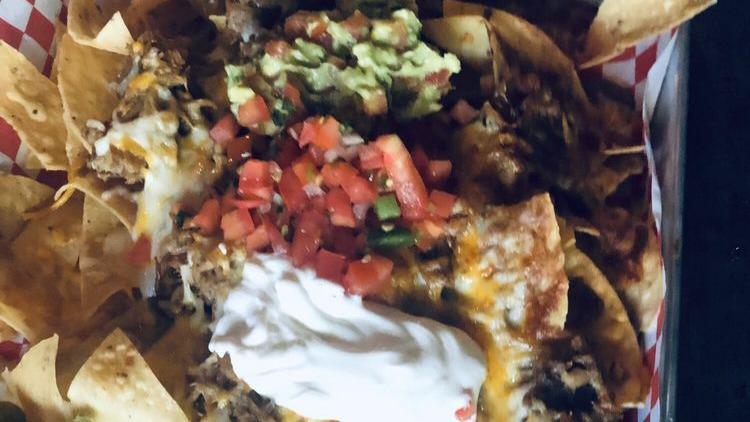 Nachos · Tortilla chips topped with refried beans, cheese, crema, pico de gallo, guacamole, and jalapeños. Add meat for an additional cost.
