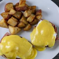 15. Eggs Benedict · Poached eggs on a muffin with ham, Hollandaise sauce, and country red potatoes.