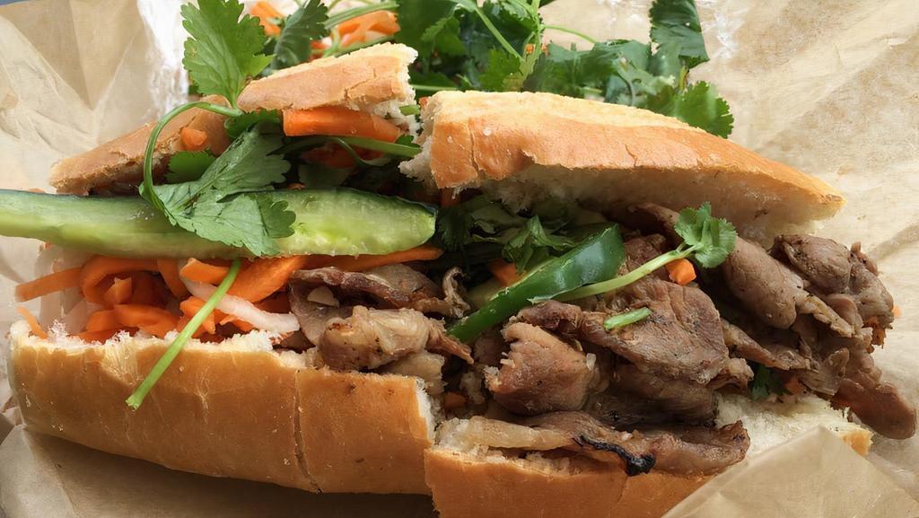 Vegetarian Banh Mi · Vietnamese sandwich with mayonnaise, cucumber, pickled carrots, cilantro, and jalapeno on side.