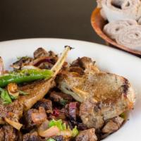 Darek Tibs · Lamb cubes grilled crispy and with two lamb chops, red onion, hot pepper, garlic and organic...