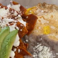 Regular Chilaquiles · Fried Tortillas chips with homemade red sauce, refried beans, 2 eggs, mexican cheese, sourcr...