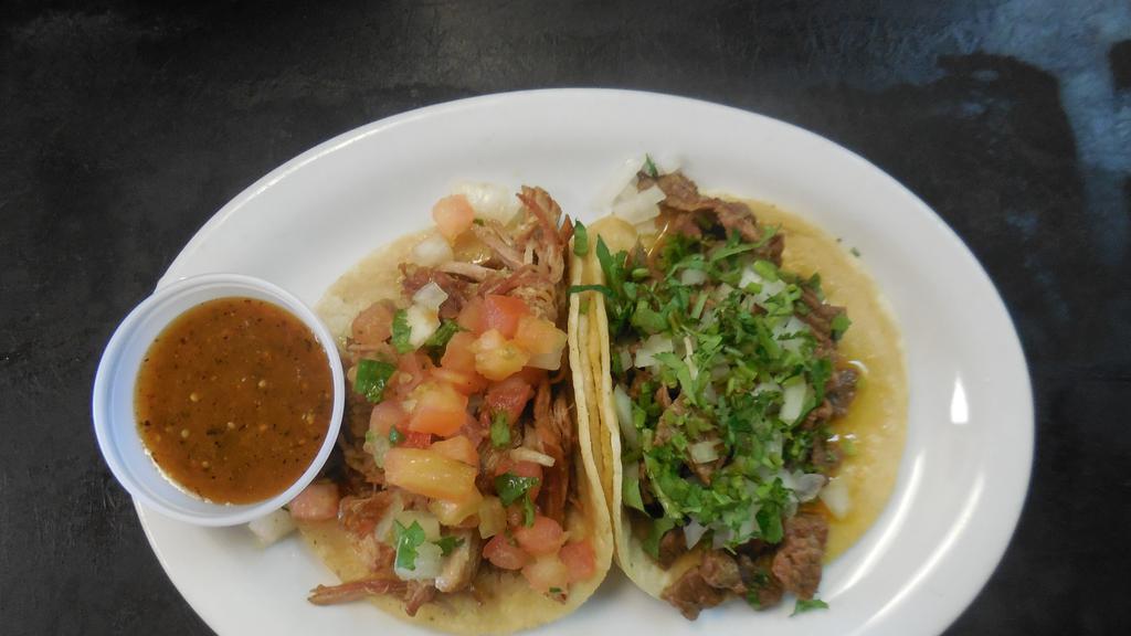 Tacos · Small, soft corn tortilla garnished with cilantro, onions and hot chile sauce.