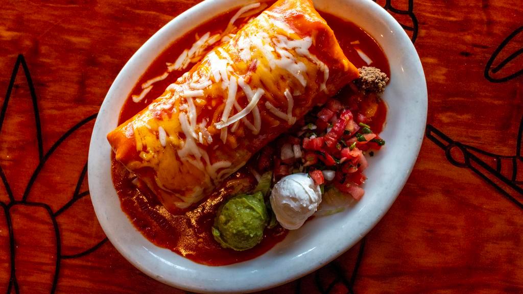 Wet Burrito · Large flour tortilla filled with chicken, beef or pork, rice and refried beans. Smothered with enchilada sauce and cheese, garnished with guacamole, sour cream and fresh salsa.