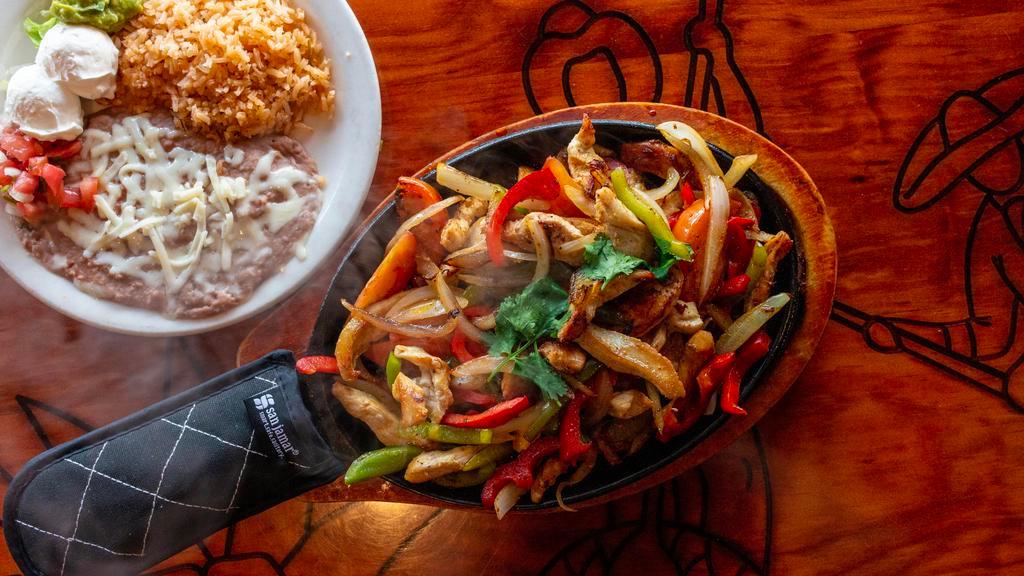 Fajitas · Marinated strips of beef or chicken freshly grilled to order with fresh tomatoes, onions and bell peppers. Served with rice, beans, corn or flour tortillas, guacamole and sour cream.