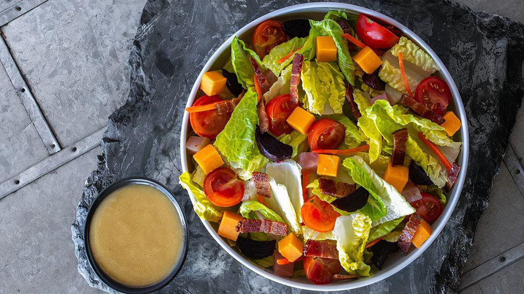 Rocketbird House Side Salad · A half-size portion of the Rocketbird House Salad. Romaine Hearts, Little Gem Lettuce, Aged Cheddar, Applewood Bacon, Roasted Beets, Cherry Tomatoes, Carrots, Golden Balsamic Vinaigrette. Dressings are served on the side.