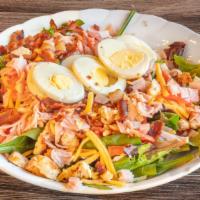 Chicken Cobb Salad · Grilled chicken breast layered over spring mix with sliced ham, cheese, tomatoes, egg and ba...