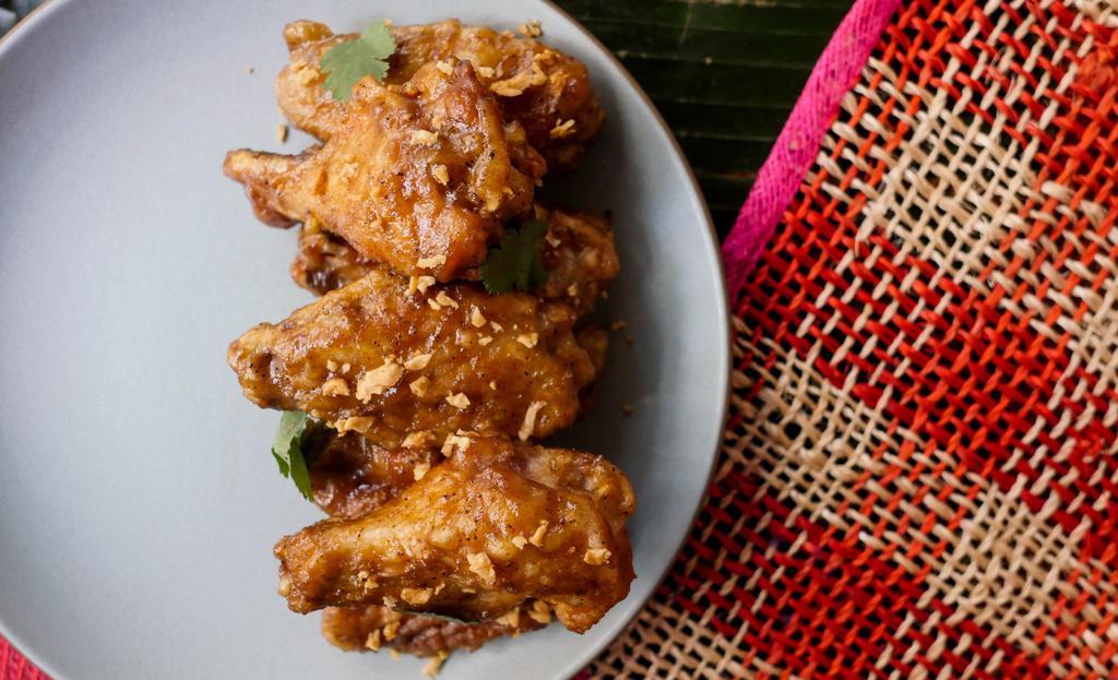GARLIC ADOBO WINGS · Filipino adobo butter sauce, topped with fried garlic and cilantro. Contains dairy